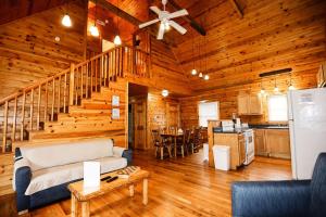 ein Wohnzimmer mit einem Sofa und einer Treppe in einer Hütte in der Unterkunft The Cabins at Pine Haven - Beckley in Beaver
