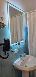 a bathroom with a sink and a mirror and a phone at Apartments Athina Orikum in Orikum