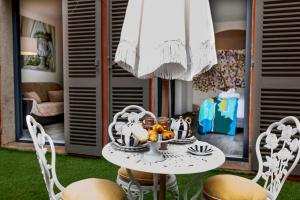 een tafel en stoelen in de woonkamer bij La Bravade Luxe et sérénité au cœur de Saint-Tropez Suites spacieuses avec jardin enchanteur in Saint-Tropez