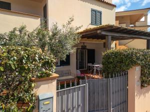 a fence in front of a house with a table at Orosei Home Holidays - Sa Vadde in Cala Liberotto