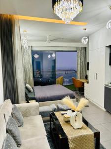 a living room with a couch and a bed and a chandelier at Luxury Heights with City View and River View in Noida