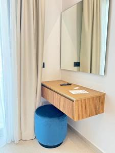 a dressing table with a blue stool and a mirror at Tramonto Maisonettes & Suites in Parga