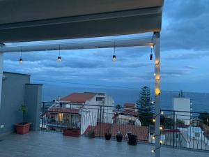 a view of the ocean from a balcony with lights at Andi Casa - Sicilia - vista mare in Santa Teresa di Riva