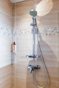 La salle de bains est pourvue d'une douche avec un pommeau de douche. dans l'établissement La Bravade Luxe et sérénité au cœur de Saint-Tropez Suites spacieuses avec jardin enchanteur, à Saint-Tropez