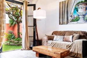 uma sala de estar com um sofá e uma mesa de centro em La Bravade Luxe et sérénité au cœur de Saint-Tropez Suites spacieuses avec jardin enchanteur em Saint-Tropez