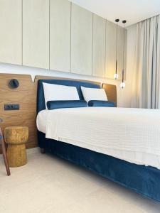 a bedroom with a large bed with blue and white sheets at Tramonto Maisonettes & Suites in Parga