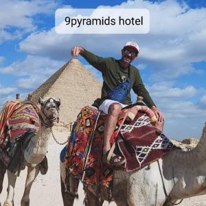 a man riding on the back of a camel in front of a pyramid at 9pyramids hotel in Cairo