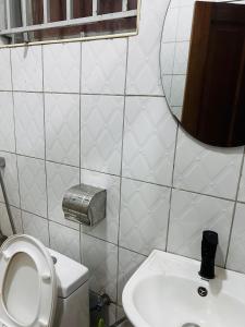 a bathroom with a toilet and a mirror and a sink at The home hive apartment in Kampala