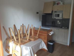 a kitchen with a table with four wooden chairs at Charmant studio vu sur la montagne in Le Biot