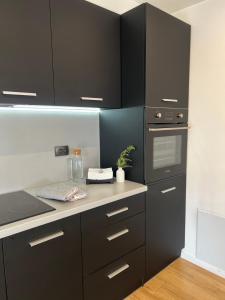 una cucina con armadi neri e piano di lavoro di Hyggemate - Апартаменти a Sarnitsa