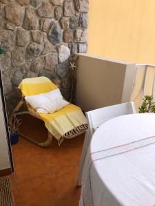 - une chambre dotée d'un mur en pierre et d'une chaise avec un oreiller dans l'établissement Plein Sud, à Cassis