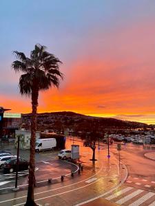 a palm tree in a parking lot with a sunset at Apartment #Story in Koper