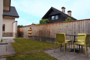 een tafel en stoelen in een achtertuin met een hek bij Domen's cozy rentals in Kranj