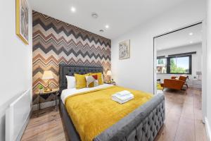 um quarto com uma cama com um cobertor amarelo em Spacious 1 Bed Flat - Near Heathrow - UB3 London em Londres