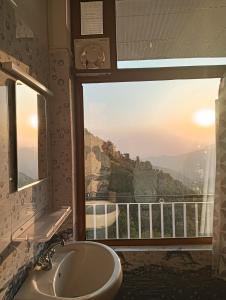 a bathroom with a sink and a window with a view at Amazing view Home Stay in McLeod Ganj