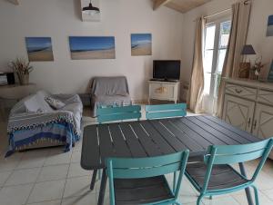 ein Zimmer mit Tisch und Stühlen und ein Schlafzimmer in der Unterkunft La Grande Margotte by Edgar et Alfred in Saint-Georges-dʼOléron