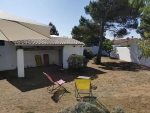 zwei Stühle in einem Hof vor einem Haus in der Unterkunft La Grande Margotte by Edgar et Alfred in Saint-Georges-dʼOléron + 2 Fotos