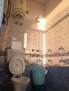 een badkamer met een toilet en een emmer bij Amazing view in McLeod Ganj