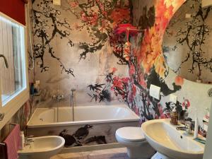 a bathroom with a tub and a toilet and a sink at purple nest in Sale Marasino