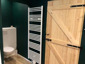La salle de bains est pourvue d'une porte de grange et de toilettes. dans l'établissement Les écuries - Maison entière, à Spa
