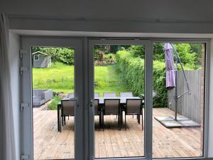 a sliding glass door with a table and chairs on a patio at Les écuries - Maison entière in Spa