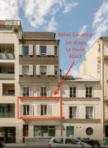 a tall white building with a sign on it at Relais Cocorico "Poule" 1 Bedroom with AC Eiffel Tower district in Paris