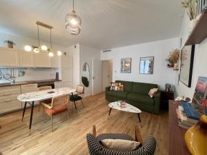 a living room with a green couch and a table at Relais Cocorico "Poule" 1 Bedroom with AC Eiffel Tower district in Paris