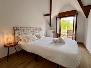 a bedroom with a large white bed with a window at Apartamento La Fuente - Monabri in Somo