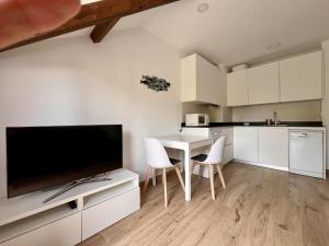 a kitchen with white cabinets and a table with chairs at Apartamento La Fuente - Monabri in Somo +18 photos
