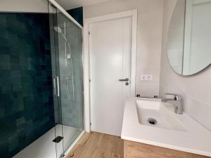 a bathroom with a sink and a glass shower at Apartamento La Fuente - Monabri in Somo