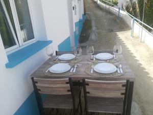 a table with plates and wine glasses on it at Casinhas Proença - Friends in Aljezur +18 photos