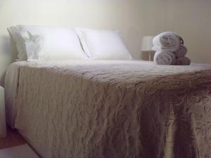 a bed with two towels sitting on top of it at Casinhas Proença - Friends in Aljezur
