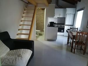 a kitchen and a living room with a staircase and a table at Casinhas Proença - Friends in Aljezur