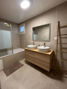 a bathroom with two sinks and a tub and a mirror at Appartement Bezons - La Défense in Bezons