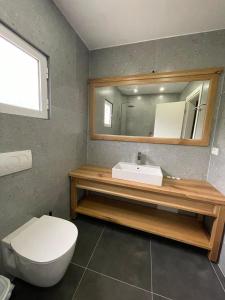 y baño con lavabo, aseo y espejo. en Hotel Jali, en Himare