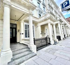 a white building with white columns and a door at MSK Premium in London