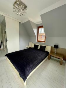 a bedroom with a large bed with a black comforter at Apartamenty-Baltivia in Hel +70 photos