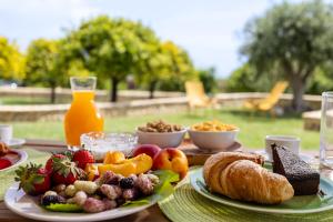 a table topped with plates of food and fruit at Fiore di Vendicari B&B - Sicilian Charme, Lemon Grove and Sea in Noto