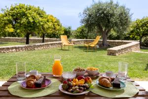 a table with plates of food and fruit on it at Fiore di Vendicari B&B - Sicilian Charme, Lemon Grove and Sea in Noto