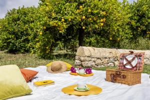 a picnic table with hats and food on it at Fiore di Vendicari B&B - Sicilian Charme, Lemon Grove and Sea in Noto