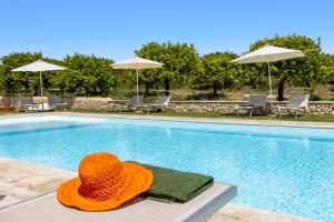 an orange hat sitting next to a swimming pool at Fiore di Vendicari B&B - Sicilian Charme, Lemon Grove and Sea in Noto