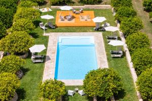 an overhead view of a swimming pool with umbrellas and chairs at Fiore di Vendicari B&B - Sicilian Charme, Lemon Grove and Sea in Noto