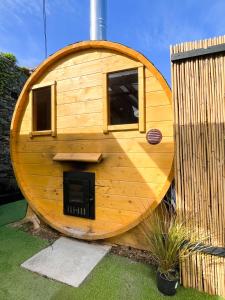 una casa circolare in legno con un camino in un cortile di Greystones Glamping - Tent 3 a Greystones Altre 5 foto