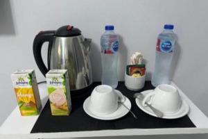 a counter with a tea pot and cups and bottles of water at 9pyramids hotel in Cairo