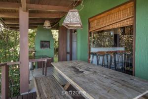 een houten tafel op de veranda van een huis bij Casa com vista p mar em Garopaba PSV000 in Garopaba