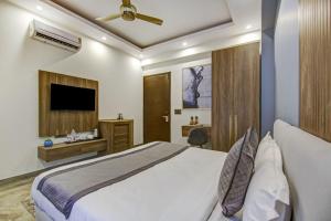 une chambre d'hôtel avec un lit et une télévision dans l'établissement The Embassy Inn, à Noida
