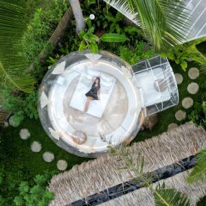 an overhead view of a woman sitting on a table at Bubble Siargao in General Luna