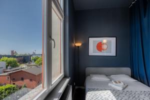 a bedroom with a bed and a large window at Art Apartment in Toruń