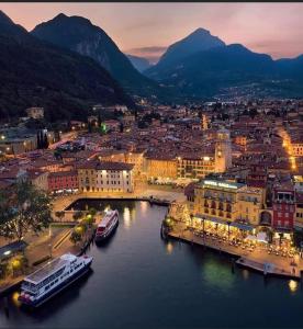 Una ciudad con barcos en el agua por la noche en San Rocco Apartments 2, en Riva del Garda