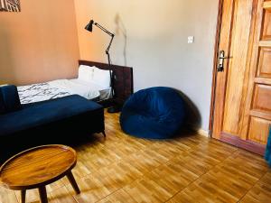 a room with a bed and a blue bean bag chair at The Urban Edge in Makerere